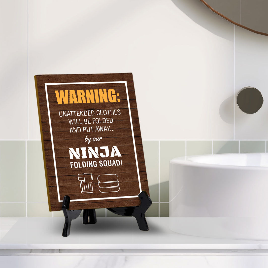 Signs ByLITA Warning: Unattended clothes will be folded and put away... by our ninja folding squad! Table Sign with Acrylic Stand (6x8“)