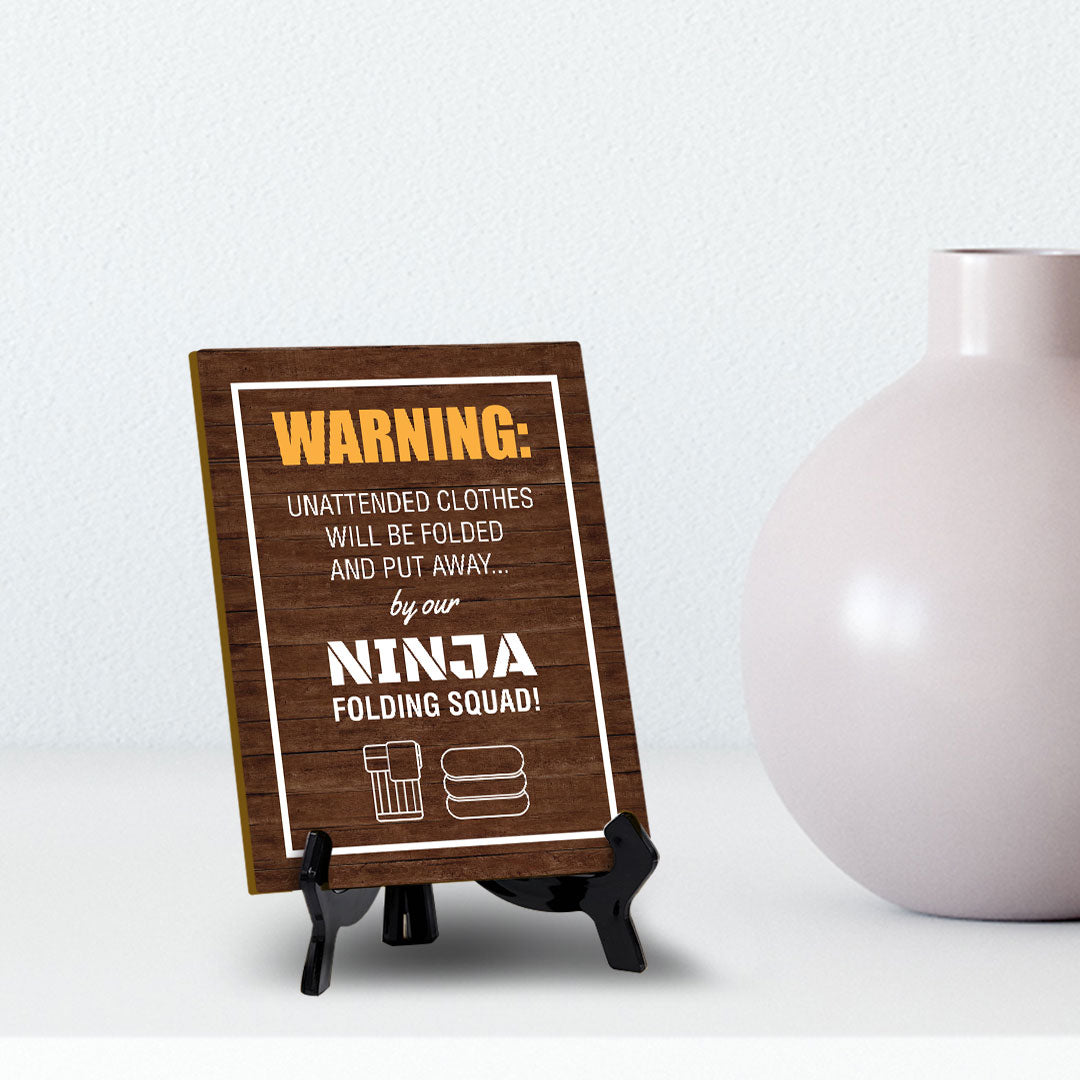 Signs ByLITA Warning: Unattended clothes will be folded and put away... by our ninja folding squad! Table Sign with Acrylic Stand (6x8“)