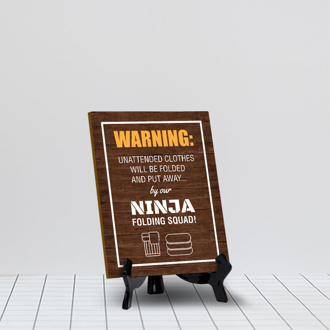 Signs ByLITA Warning: Unattended clothes will be folded and put away... by our ninja folding squad! Table Sign with Acrylic Stand (6x8“)